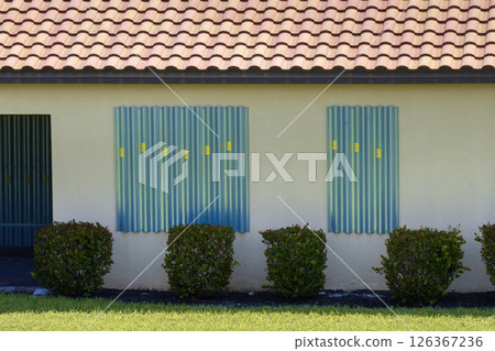 Hurricane shutters made from steel mounted for protection of house windows. Protective measures before natural disaster in Florida Hurricane shutters made from steel mounted for protection of house windows. Protective measures before natural disaster in Florida 126367236