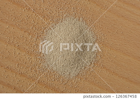 Top View of Granulated Yeast Scattered on Table. 126367458