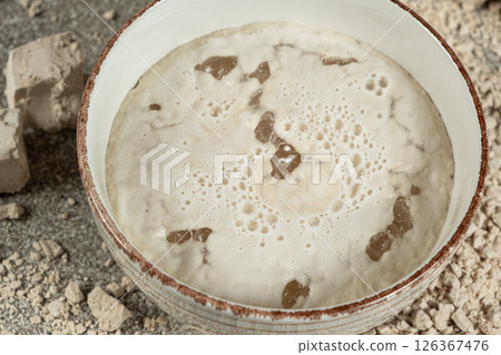 Activation of wet fresh yeast in warm water with sugar. 126367476