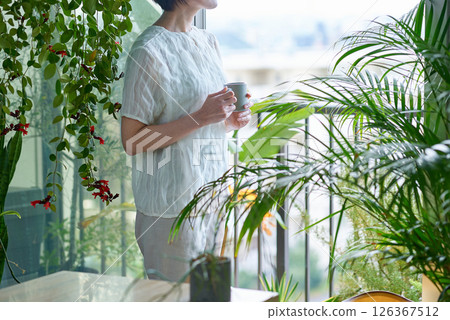 一個被觀葉植物包圍的女人 126367512