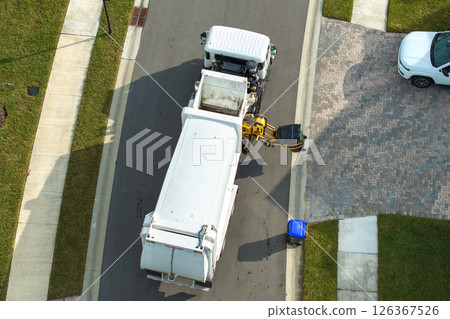 Garbage truck loading trash bin from the curb of American neighborhood 126367526