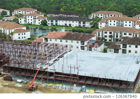 Development of commercial housing in USA. Construction works on monolithic frame. Large building site with scattered workers and equipment. Real estate market Development of commercial housing in USA. Construction works on monolithic frame. Large building site with scattered workers and equipment. Real estate market 126367840