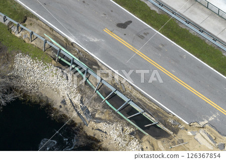 Destroyed bridge after hurricane flooding in Florida. Construction roadwork site. Reconstruction of damaged road after flood water washed away asphalt Destroyed bridge after hurricane flooding in Florida. Construction roadwork site. Reconstruction of damaged road after flood water washed away asphalt 126367854