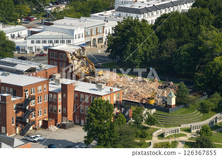 Demolition of old residential building. Crawler excavator demolishing brick walls of outdated structure Demolition of old residential building. Crawler excavator demolishing brick walls of outdated structure 126367855