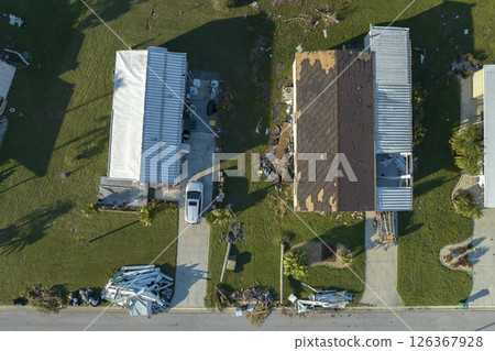Consequences of natural disaster. Severely damaged houses after hurricane Ian in Florida mobile home residential area 126367928
