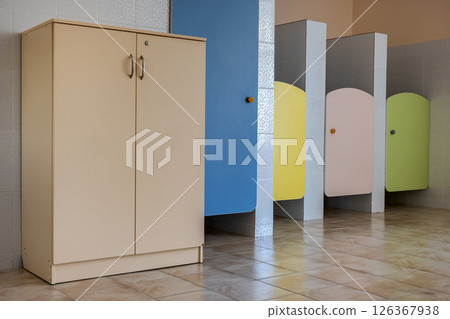 Colorful toilet doors in elementary school bathroom interior. 126367938