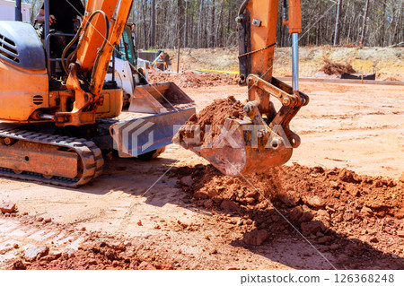 Heavy machinery is digs trench moving dirt at construction site Heavy machinery is digs trench moving dirt at construction site 126368248