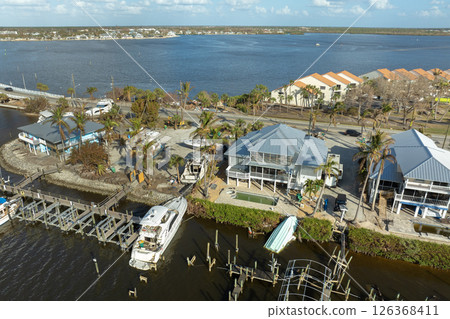 Capsized sunken sailing boat left forsaken on shallow bay waters after hurricane Milton in Englewood, Florida 126368411