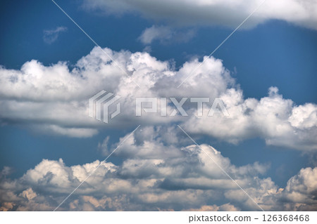 Bright landscape of white puffy cumulus clouds on blue clear sky. Bright landscape of white puffy cumulus clouds on blue clear sky. 126368468