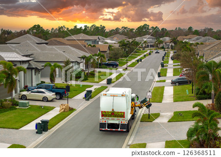 Automated modern garbage collector truck loading waste on Florida town street. Municipal services 126368511
