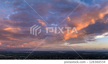 Amazing evening skyscape. Sunset sky with bright colorful clouds over dark landscape Amazing evening skyscape. Sunset sky with bright colorful clouds over dark landscape 126368534