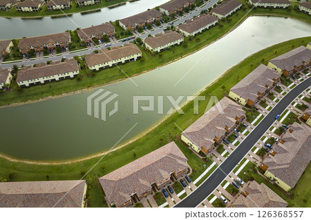 Aerial view of tightly located family houses with retention ponds to prevent flooding in Florida closed suburban area. Real estate development in american suburbs Aerial view of tightly located family houses with retention ponds to prevent flooding in Florida closed suburban area. Real estate development in american suburbs 126368557