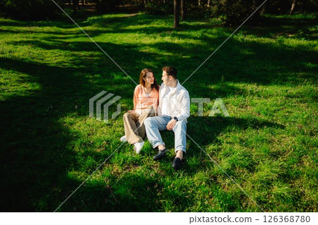 Couple enjoying a sunny afternoon together in a peaceful park setting 126368780