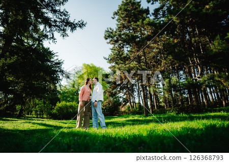 Couple sharing a tender moment in a serene forest clearing at sunset 126368793