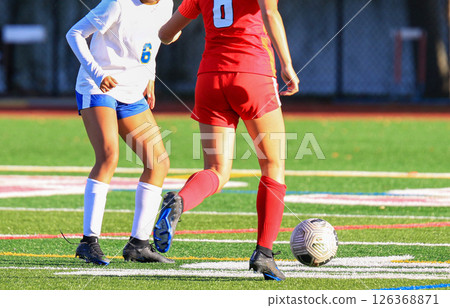 Girls Playing Soccer on a Turf Field During a Sunny Day 126368871