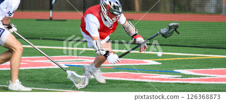 Lacrosse Players Competing for the Ball on a Vibrant Turf Field 126368873