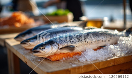 Fresh salmon displayed on ice at outdoor market stall. 126369112