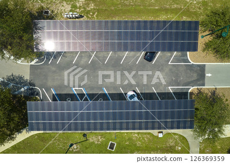 Aerial view of solar panels installed as shade roof over parking lot for parked cars for effective generation of clean electricity. Photovoltaic technology integrated in urban infrastructure 126369359