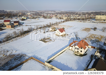 Aerial view of residential houses with snow covered roofops in suburban rural town area in winter Aerial view of residential houses with snow covered roofops in suburban rural town area in winter 126369379