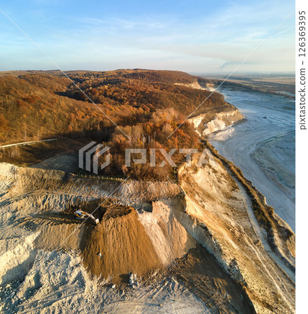 Aerial view of open pit mine of sandstone materials for construction industry with excavators and dump trucks. Heavy equipment in mining and production of useful minerals concept Aerial view of open pit mine of sandstone materials for construction industry with excavators and dump trucks. Heavy equipment in mining and production of useful minerals concept 126369395