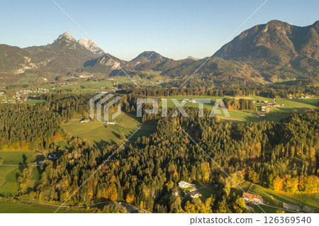 Aerial view of green meadows with villages and forest in austrian Alps mountains. Aerial view of green meadows with villages and forest in austrian Alps mountains. 126369540