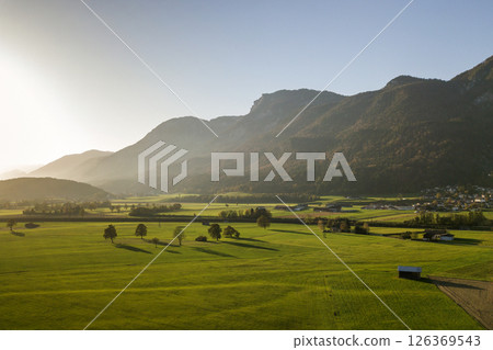 Aerial view of green meadows with villages and forest in austrian Alps mountains. Aerial view of green meadows with villages and forest in austrian Alps mountains. 126369543