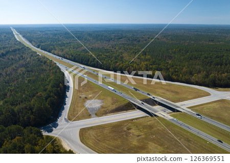 Aerial view of freeway overpass junction with fast moving traffic cars and trucks in american rural area. Interstate transportation infrastructure in USA Aerial view of freeway overpass junction with fast moving traffic cars and trucks in american rural area. Interstate transportation infrastructure in USA 126369551