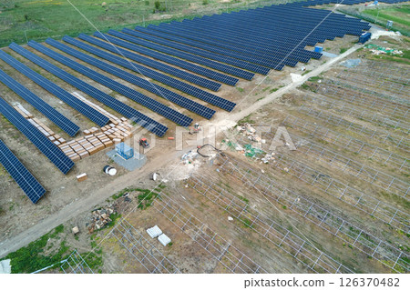Aerial view of big electric power plant under construction with many rows of solar panels on metal frame for producing clean electrical energy. Development of renewable electricity sources 126370482
