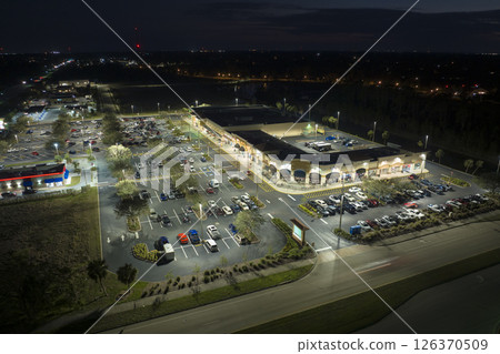 Aerial night view of many cars parked on parking lot with lines and markings for parking places and directions. Place for vehicles in front of a grocery mall store 126370509