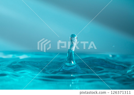 Water droplets fall down closely into the blue water, making it the perfect center in nature 126371311