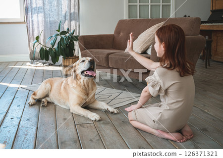 Cute girl training a Labrador dog at home 126371321