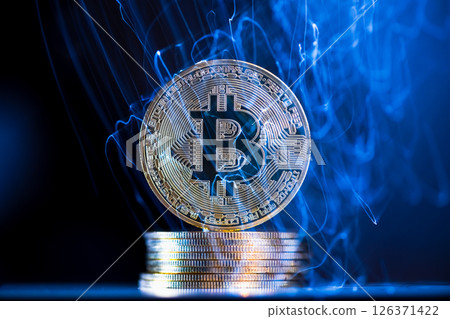 Glowing blue energy is flowing through and around a large, physical bitcoin cryptocurrency coin resting on a stack of coins, representing the dynamic and volatile nature of digital currencies Glowing blue energy is flowing through and around a large, physical bitcoin cryptocurrency coin resting on a stack of coins, representing the dynamic and volatile nature of digital currencies 126371422