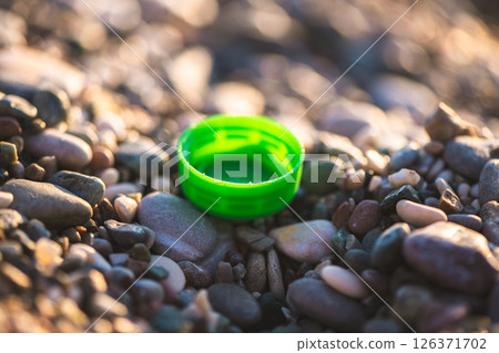 plastic bottle cap on the beach, environmental pollution 126371702