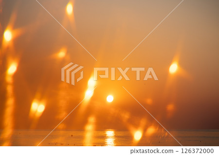 Beautiful sunset or sunrise on the sea, clear sky, natural delicate background with beautiful highlights, sky and sun at sunrise 126372000