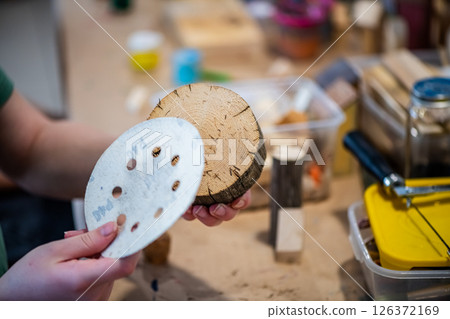 cute teen girl at a master class making a craft from wood, exhibition of crafts, crafts fair, education, master classes cute teen girl at a master class making a craft from wood, exhibition of crafts, crafts fair, education, master classes 126372169