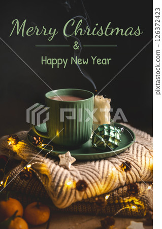 Green mug of hot chocolate resting on a plate with tangerines, surrounded by lit candles, warm sweaters, pine cones, and the soft glow of christmas lights, creating a cozy atmosphere, greeting card 126372423