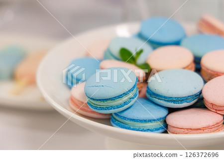 Colorful macarons displayed elegantly on a white plate at a festive dessert table celebration 126372696