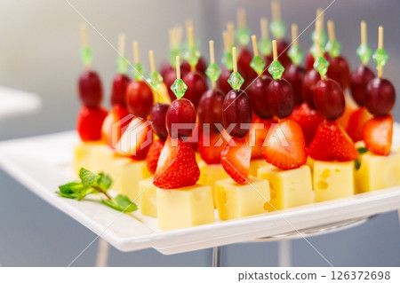 Delightful fruit and cheese skewers served at a vibrant summer garden party 126372698