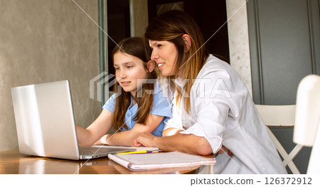 Business woman, freelancer and mom trying to work from home and spending time with daughter. Online business and freelance concept. Business woman, freelancer and mom trying to work from home and spending time with daughter. Online business and freelance concept. 126372912