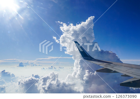 Soaring Above the Clouds, A Stunning Aerial View from a Plane Window with Towering Cumulus Clouds 126373090