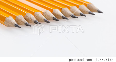 yellow graphite pencils with sharp tips lined up on a white background. Great for office use and art supplies 126373158