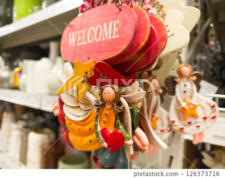Colorful handmade welcome ornaments displayed in a charming store setting Colorful handmade welcome ornaments displayed in a charming store setting 126373716