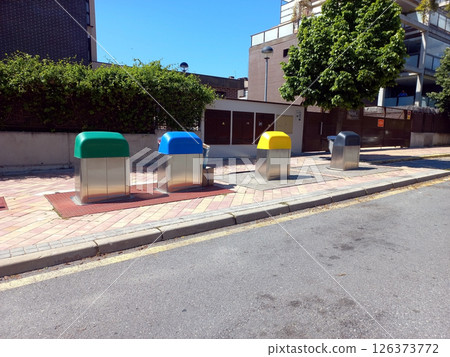 Urban recycling initiative: color-coded waste bins in residential area for efficient waste sorting Urban recycling initiative: color-coded waste bins in residential area for efficient waste sorting 126373772