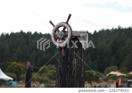 Ship's Wheel Affixed To A Post At The Pier Ship's Wheel Affixed To A Post At The Pier 126374033