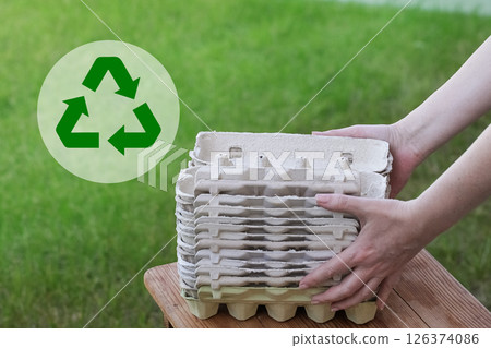 Empty Egg Cartons, Paper Container on Green Grass background. Recycling Concept 126374086