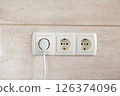 Electrical plug in outlet socket at home. 126374096