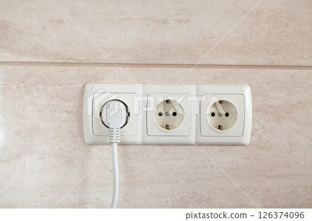 Electrical plug in outlet socket at home. Electrical plug in outlet socket at home. 126374096