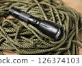 Khaki rope and black flashlight, Concept survival first aid, tools, Mountaineering Safety Equipment. 126374103