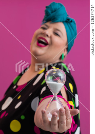 Stylish Woman Holding Hourglass Against Pink Background 126374714