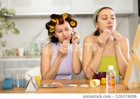 Two women cleanse their face with cotton pads 126374886
